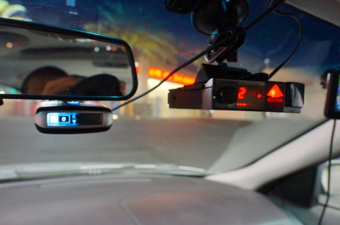 2003 Ford Taurus - Interior view of a car's dashboard showing a radar detector and a GPS device mounted on the windshield.