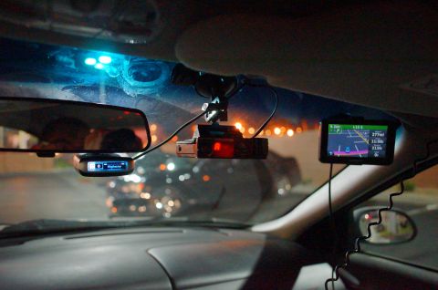 2003 Ford Taurus - View from inside a car at night, with various electronic devices mounted on the dashboard and windshield.