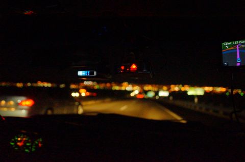 2003 Ford Taurus - The view from inside a car driving on a highway at night, with other vehicles on the road and a GPS navigation system visible.
