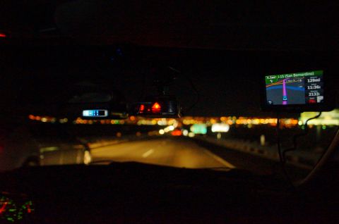 2003 Ford Taurus - View from inside a car at night, showing the dashboard with navigation and a radar detector, with city lights blurred in the background.