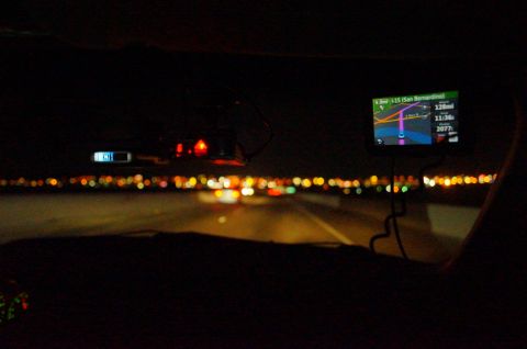 2003 Ford Taurus - The view from inside a vehicle at night, with a GPS displaying navigation information.