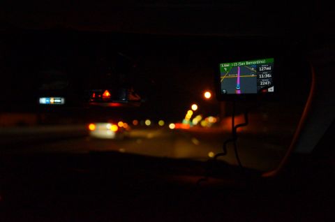 2003 Ford Taurus - Nighttime interior view from a vehicle, displaying a GPS navigation screen with route information.