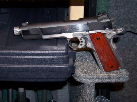 1995 Mercury Grand Marquis - A close-up view of a Colt 1911 pistol resting on a gun case.