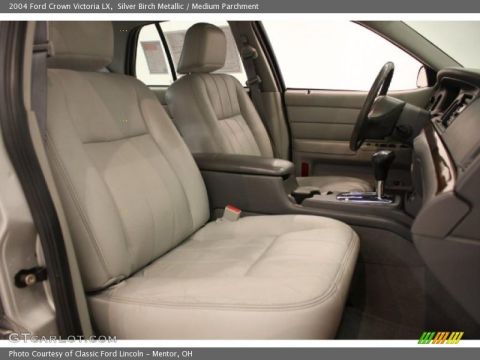 1995 Mercury Grand Marquis - The interior of a car features light gray leather seats and a gray dashboard with wood trim accents.