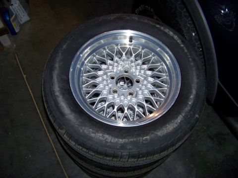 1999 Mercury Grand Marquis - A close-up view shows a stack of tires, with one custom alloy wheel prominently displayed on the uppermost tire.