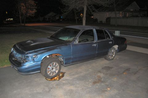 1985 Mercury Grand Marquis - This blue sedan has a damaged front end, missing grille, and appears to be leaking fluid.