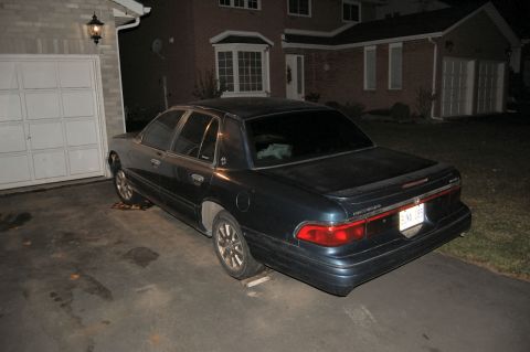 1985 Mercury Grand Marquis - Dark sedan parked in a driveway at night, showing its rear and side profile.