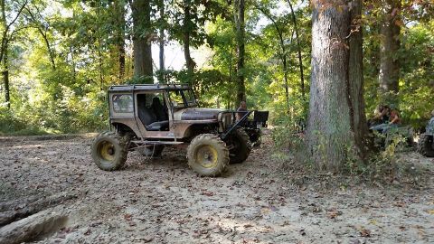 Off-road vehicle with large tires on a muddy trail in the woods