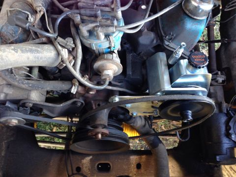 1979 Ford Bronco - Close-up view of the engine compartment, focusing on the power steering system and associated components.