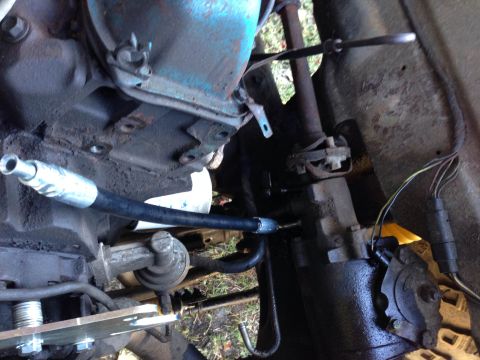 1979 Ford Bronco - Close-up view of engine and steering system parts, including a hydraulic hose and wiring.