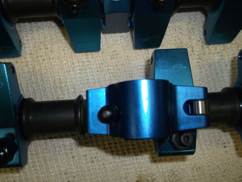 1971 Ford Ranchero - Close-up view of blue metal engine components, possibly rocker arms and shafts, on a textured surface.