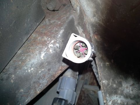 1991 Ford F-250 - Close-up of a vehicle's electrical connector and rusty frame, with visible text from Supermotors.net.