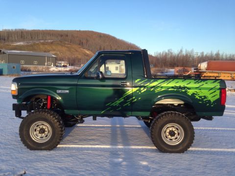1993 Ford Bronco - This lifted Ford Bronco is shown in profile, with a custom graphic design on its side.