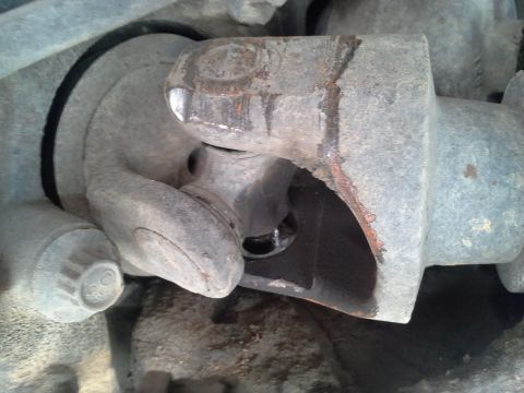 1991 Ford F-250 - Close-up of a damaged driveshaft universal joint, showing rust and wear.