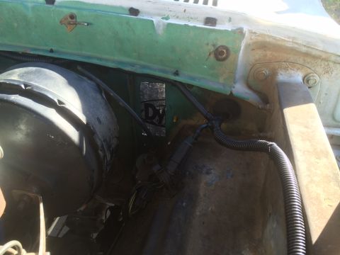 1977 Ford F-350 - The wiring and brake booster are visible in the engine bay of this vehicle.