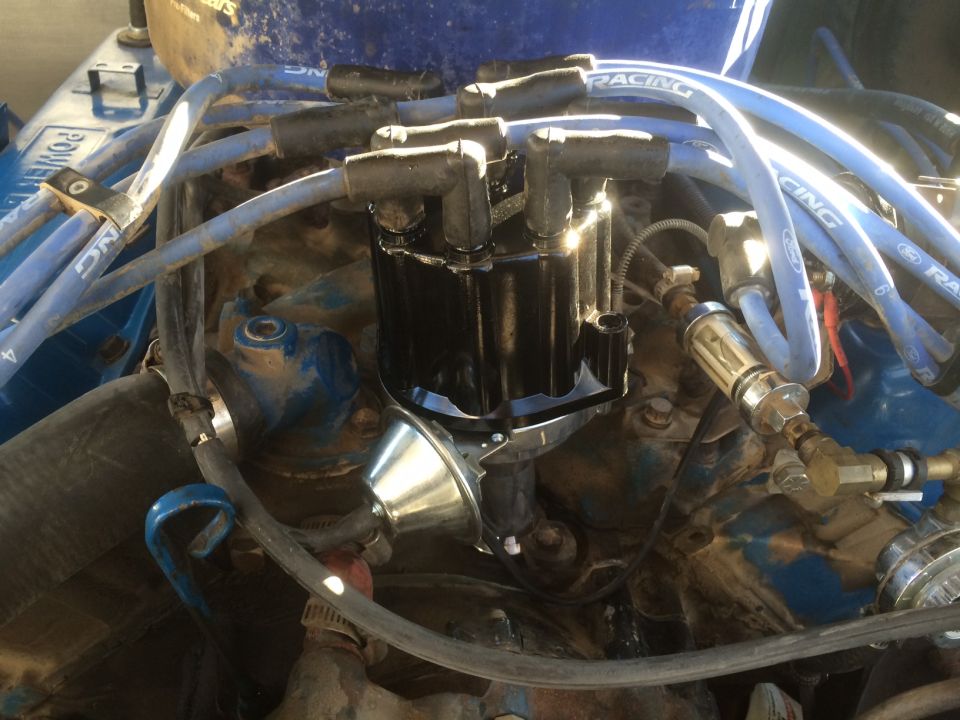 Ford V8 engine distributor cap with blue spark plug wires attached