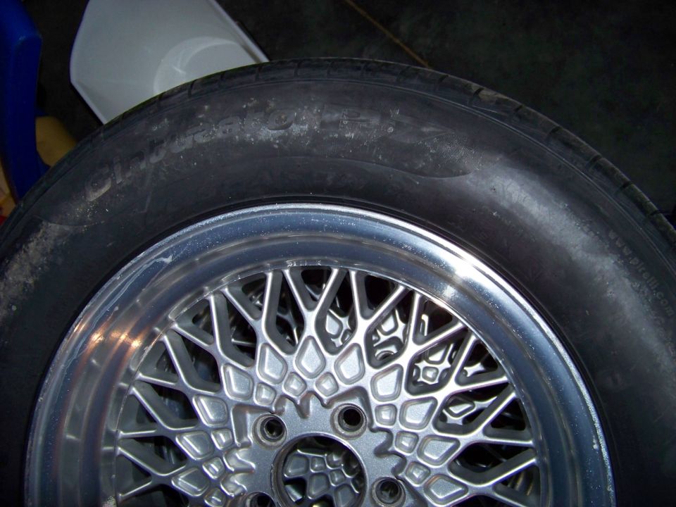 Wire wheel with intricate spokes and a tire, Supermotors.net logo visible