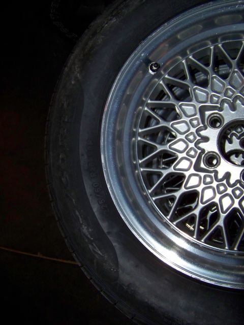 1999 Mercury Grand Marquis - A close-up view of a custom mesh wheel and tire, with some text visible on the tire's sidewall.