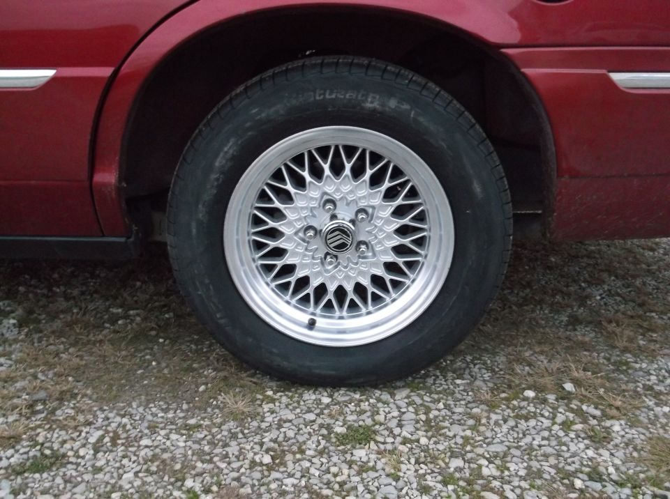 1999 Mercury Grand Marquis wheel with silver mesh rim and Mercury logo