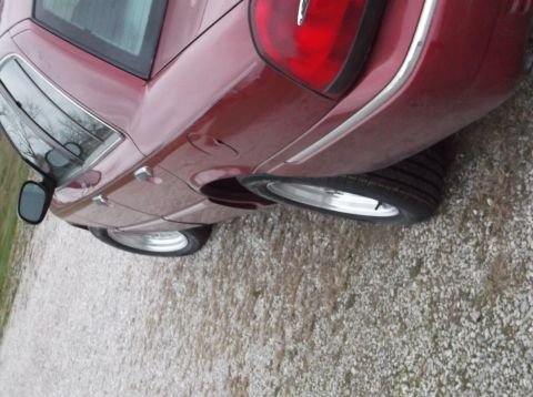 1999 Mercury Grand Marquis - This red sedan has a distinctive taillight and chrome trim, with aftermarket wheels fitted.