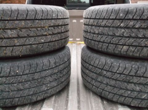 1999 Mercury Grand Marquis - A set of four used tires are piled in the bed of a pickup truck, with a website watermark at the bottom right.