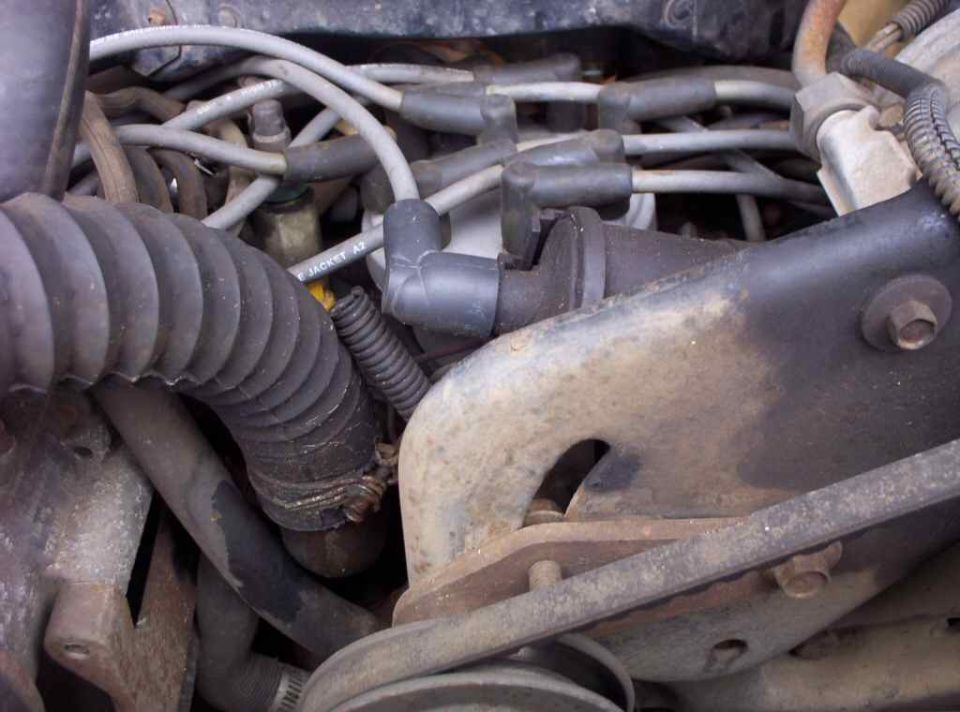 Engine detail with spark plug wires, ribbed boot, cast bracket and 'JACKET A2' marked hose