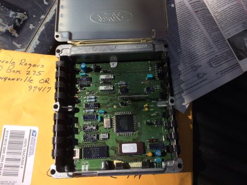 1990 Ford F-150 - A Ford electronic control unit is shown with its cover open, revealing the internal circuitry and components.