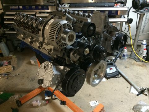1996 Ford Bronco - Engine assembly on an orange stand, showing the alternator, air conditioning compressor, and various pulleys.