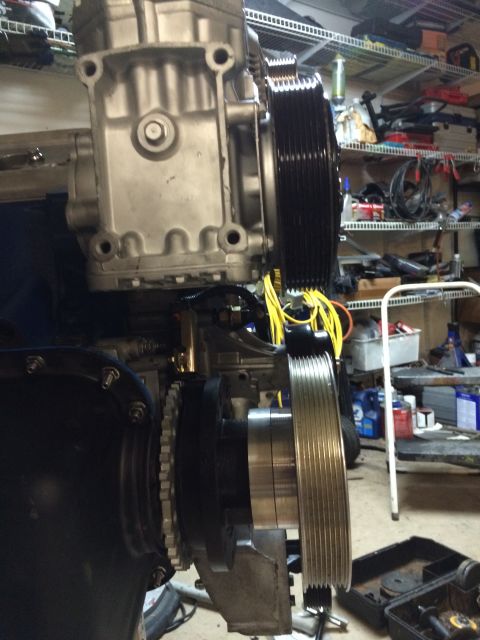1996 Ford Bronco - Close-up of a supercharger assembly with pulleys and wiring in a workshop setting.