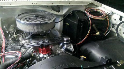 1982 Ford Bronco - Close-up view of an engine bay an Edelbrock air cleaner and a red distributor cap, with wiring visible.