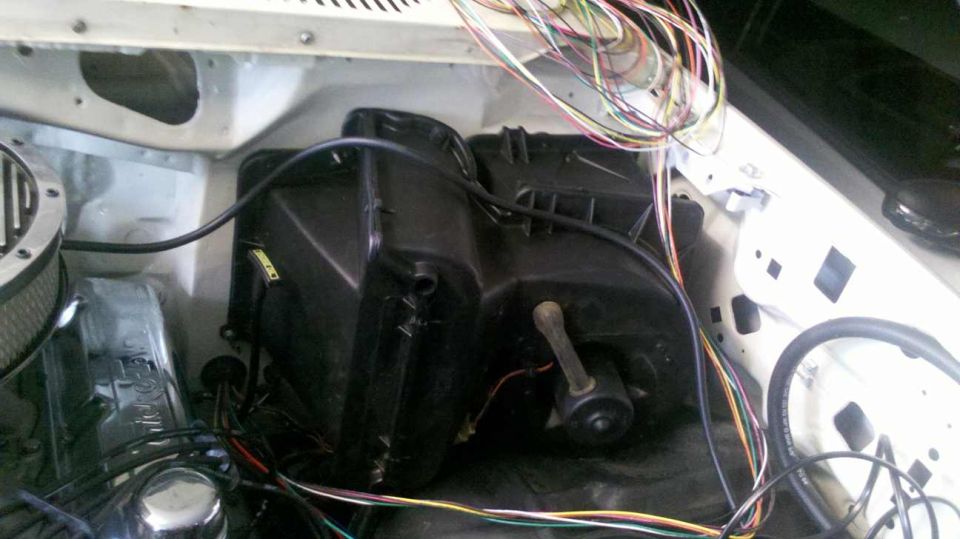 Engine bay with black HVAC unit, exposed wiring, and air filter housing