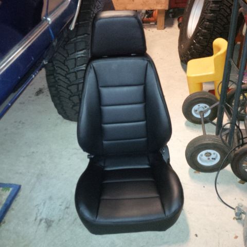 1978 Ford Bronco - A black bucket seat with a headrest is shown, not installed in a vehicle.