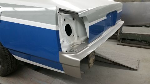 1991 Ford LTD Crown Victoria - The rear quarter panel of a car, painted with blue and white stripes, is shown during body repair work.