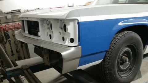 1991 Ford LTD Crown Victoria - Front end of a 1991 Ford Crown Victoria LTD in a repair shop, showing primer and blue paint on the fender.