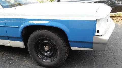 1991 Ford LTD Crown Victoria - A partial view of a 1991 Ford Crown Victoria LTD, showing its side profile with a two-tone paint scheme and primer on the front.