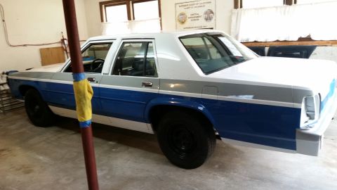 1991 Ford LTD Crown Victoria - This 1991 Ford Crown Victoria LTD is undergoing restoration in a garage, showing its two-tone paint scheme.