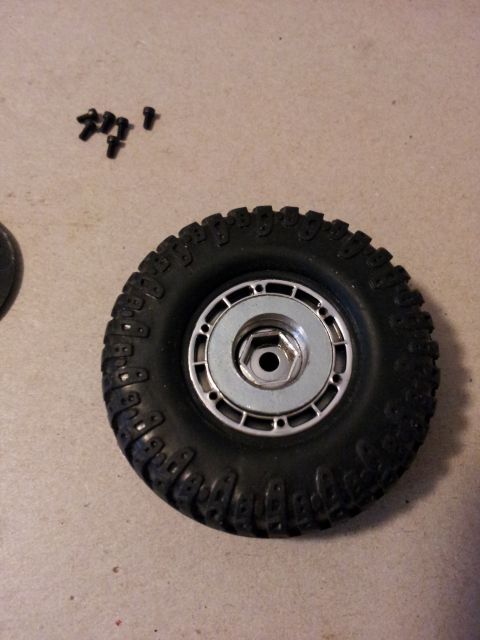 1995 Ford Bronco - RC car tire and screws on a flat surface.