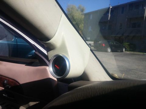 2000 Mercury Grand Marquis - A close-up view of an aftermarket gauge pod installed on the interior pillar of a vehicle.
