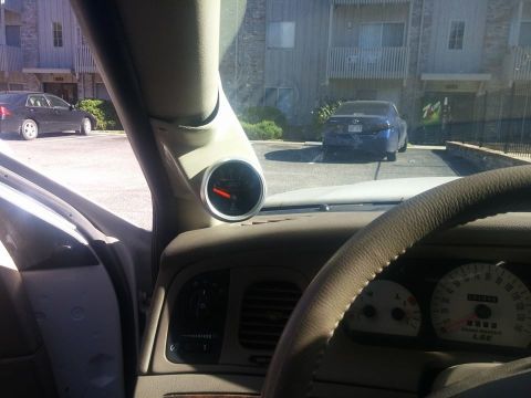 2000 Mercury Grand Marquis - Aftermarket gauge pod installed in a 2000 Mercury Grand Marquis, with another vehicle visible through the windshield.