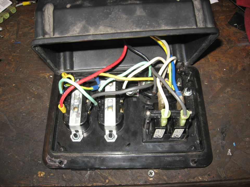 Open electrical box showing three outlets and two switches with various colored wires connected