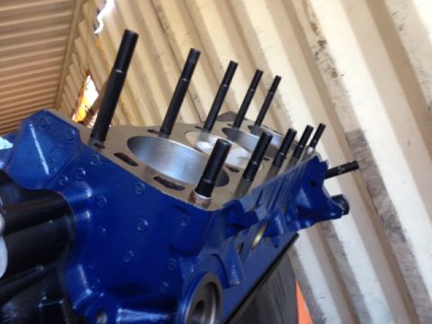 1996 Ford Bronco - A blue engine block with multiple studs protruding from the cylinder heads is shown in this close-up.