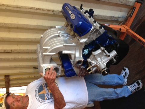 1996 Ford Bronco - Supercharged Ford V8 engine assembly with a man and an engine stand.