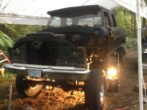 1971 Ford F-250 - This lifted Ford F-250 truck is undergoing repairs under a makeshift shelter.