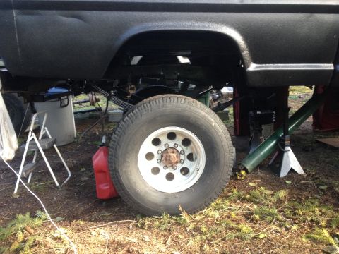 1971 Ford F-250 - Side view of a 1971 Ford F-250's rear axle and wheel assembly, supported by jack stands.
