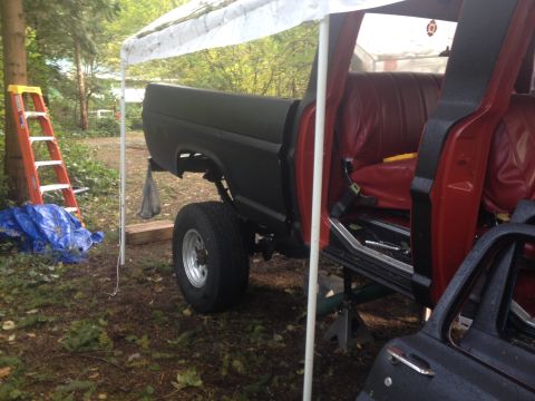1971 Ford F-250 - A lifted Ford F-Series truck with a black bed and red interior sits on jack stands outdoors.