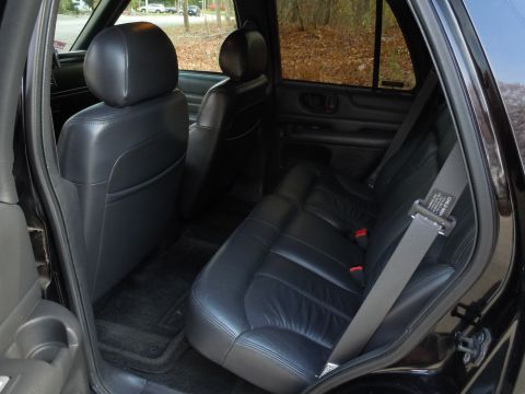 2001 Ford Crown Victoria - The interior of a black SUV shows leather seats and a seatbelt with visible text.