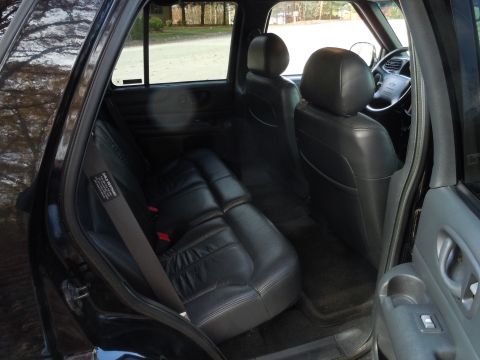 2001 Ford Crown Victoria - Interior view of a black SUV, showing the rear seats and part of the dashboard.