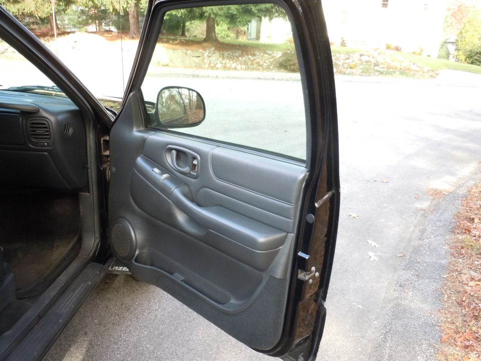 Black interior door panel and dashboard of a vehicle with the driver's door open
