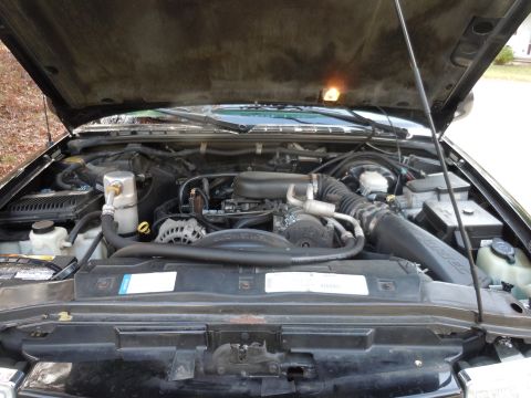 2001 Ford Crown Victoria - The engine compartment is open, revealing the mechanical components and wiring beneath the hood.
