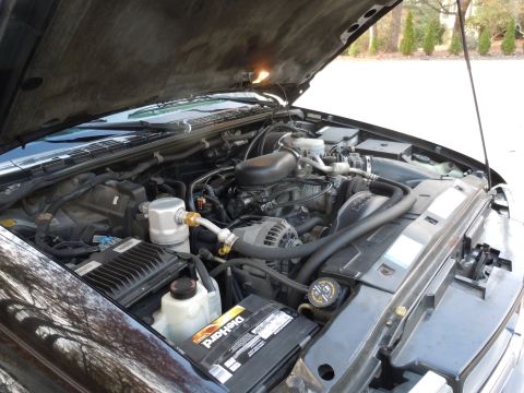 2001 Ford Crown Victoria - The engine bay of a vehicle is shown with the hood open, revealing the engine and surrounding components.